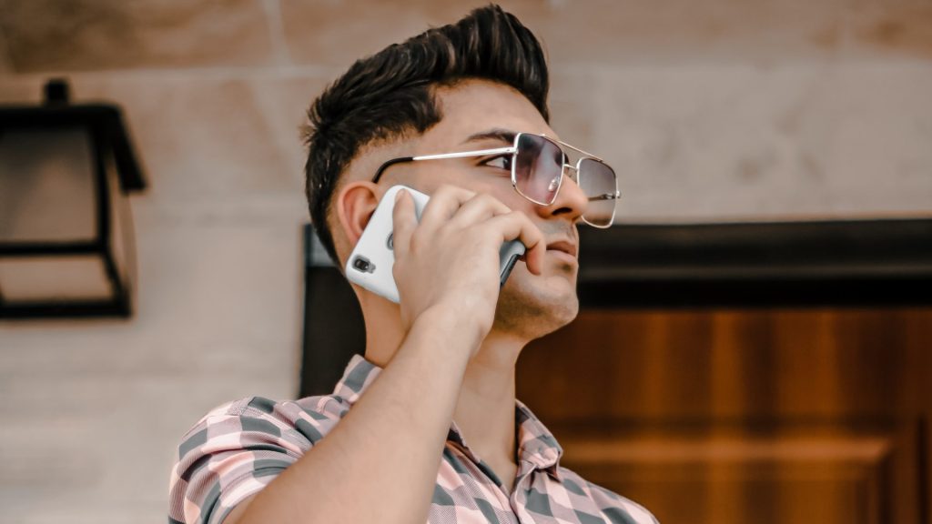 a man wearing glasses talking on a cell phone